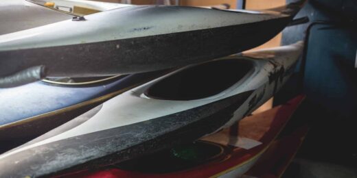 Kayaks empilés utilisés dans un garage sombre.